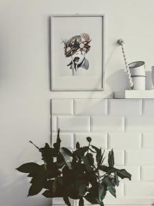 a plant in a vase next to a picture on a wall at La Mar de Ben in Muros