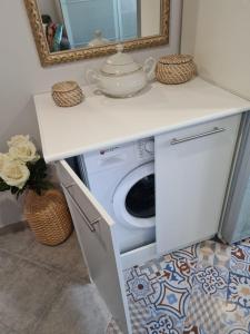 uma máquina de lavar e secar roupa debaixo de um balcão na casa de banho em Casa Coqueta em Almarda