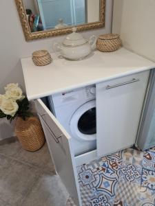 a washer and dryer under a counter in a bathroom at Casa Coqueta in Almarda