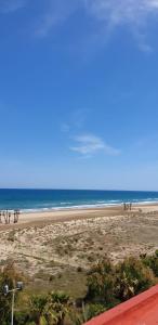 a beach with people standing on the sand and the ocean at Casa Coqueta in Almarda