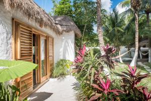 an entrance to a house with palm trees at Casa Blanca in Holbox Island