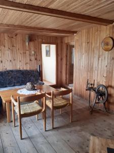 Cette chambre en bois comprend une table et des chaises en bois. dans l'établissement Brīvdienu lauku māja Budnieki, à Akmeņdziras