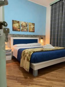 1 dormitorio con 1 cama extragrande y paredes azules en B&B Le Ginestre, en Colleferro