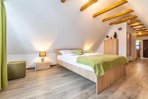 - une chambre avec un grand lit et une couverture verte dans l'établissement Manuela Residence, à Braşov
