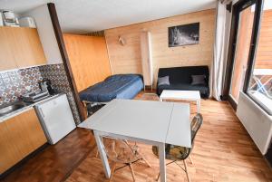 a living room with a table and a couch at Le Relai S34 - Grand et lumineux studio avec coin montagne 4-6 pers avec WIFI, 50m des pistes, grand balcon exposé SUD, DRAPS NON COMPRIS in Saint-Jean-d'Aulps