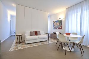 a living room with a white couch and a table at Home del Corso in Capo dʼOrlando