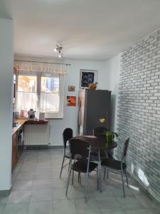uma cozinha com uma mesa e cadeiras e um frigorífico em Fischer Apartman em Hajdúszoboszló
