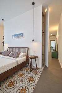 a bedroom with a bed and a table on a rug at Home del Corso in Capo dʼOrlando
