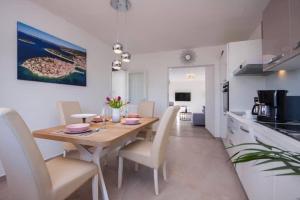eine Küche und ein Esszimmer mit einem Holztisch und Stühlen in der Unterkunft House Gruja with Pool in Primošten