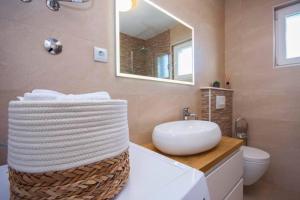 ein Badezimmer mit einem weißen Waschbecken und einem Spiegel in der Unterkunft House Gruja with Pool in Primošten + 28 Fotos