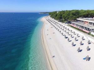 eine Luftaufnahme eines Strandes mit Sonnenschirmen und dem Meer in der Unterkunft House Gruja with Pool in Primošten