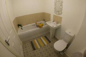 een badkamer met een toilet, een bad en een wastafel bij Cosy townhouse near Kidwelly in Kidwelly