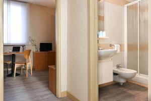 Un baño con lavabo, inodoro y escritorio. en Residence Cimarosa, en Milán 16 fotos más