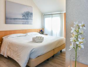 a bedroom with a bed with white sheets and a vase of flowers at Residence Cimarosa in Milan