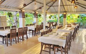 薩桑吉爾的住宿－Hotel Anil Farmhouse Gir Jungle Resort，用餐室配有白色桌椅和桌子。