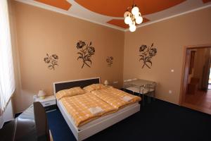 a bedroom with a bed and flowers on the wall at Pension Wunsch in Jaroměř