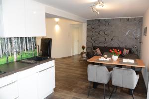 a kitchen and living room with a table and a couch at Residenz Glücksbringer in Markkleeberg