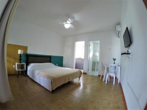 a bedroom with a bed and a table and chairs at Floripa Surf Hostel in Florianópolis