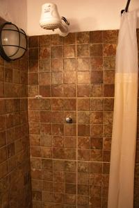 um banheiro com chuveiro e cortina em Espaço João Mineiro em Tiradentes