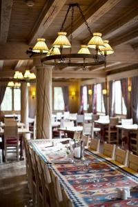 une longue table dans un restaurant avec des tables et des chaises dans l'établissement Fossheim Hotel Lom, à Lom