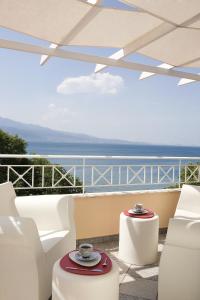 a balcony with white chairs and a view of the ocean at Akti in Nafpaktos