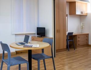 um quarto com uma mesa com um computador portátil e cadeiras em Residence Portello em Milão