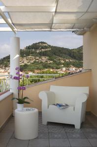 a room with a white chair and a view of a hill at Akti in Nafpaktos
