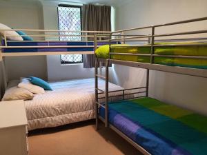 two bunk beds in a small room with at Mistral Court 14 across the road from the beach in Nelson Bay
