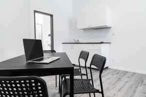 a laptop on a table with chairs in a room at NorthApartments Chemnitz in Chemnitz