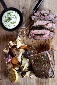 un plateau de découpe avec de la viande et un bol de sauce dans l'établissement Fossheim Hotel Lom, à Lom