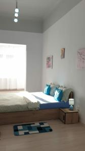 シビウにあるAPARTAMENT EMMAのベッドルーム1室(青い枕のベッド1台、窓付)