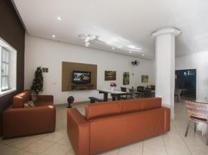 a living room with a couch and a dining room at Pousada Três Pescadores in Búzios