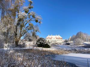 een groot wit huis in de winter met sneeuw bij Schloß Vietgest in Vietgest