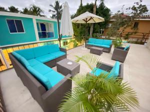 un patio con muebles azules y una sombrilla en Hotel Agua Dulce en Boca Chica