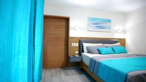 1 dormitorio con cama y cortina azul en Hotel Agua Dulce, en Boca Chica