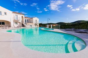 una piscina de agua azul en una casa en Residence SardegnaSummer Li Mori, en Budoni