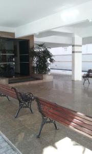 a empty building with two benches in a lobby at Enseada à 450m da praia in Guarujá