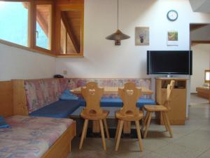 uma sala de estar com um sofá, uma mesa e cadeiras em Alpenhaus Christian em Neustift im Stubaital