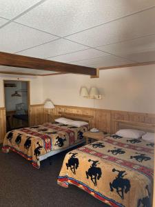 a hotel room with two beds with animals on them at Lava Mountain Lodge in Dubois