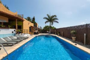 a swimming pool with lounge chairs next to a house at Villa la Atlantida in Ingenio