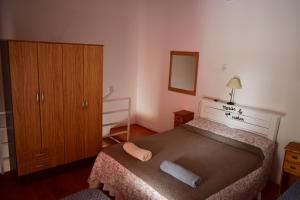 a small bedroom with a bed and a dresser at Alojamiento Neuquén in Neuquén