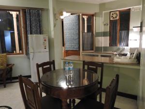 una cucina con tavolo e una cucina con frigorifero di Om Niwas Suite Hotel a Jaipur
