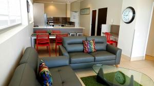 uma sala de estar com um sofá, uma mesa e uma cozinha em Laguna Serviced Apartments em Toowoomba