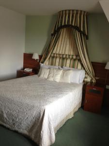 a bedroom with a large bed with a canopy at Ashbourne House Hotel in Ashbourne