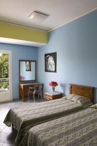 a bedroom with two beds and a desk and a window at Akti in Nafpaktos