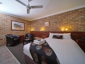 een hotelkamer met een bed en een stoel bij City View Motel in Warwick