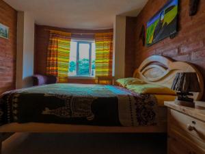 a bedroom with a bed and a window at Hostal La Casa Amarilla City in Baños