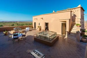 a patio with a table and chairs and a building at Dar Bladi in Ouarzazate