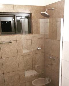 プエルトイグアスにあるCabaña Omaのバスルーム(シャワー、トイレ付)、窓が備わります。