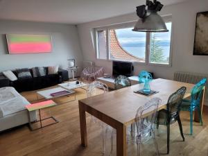 a living room with a wooden table and chairs at 3-bedroom apartment with spectacular view in Neuchâtel